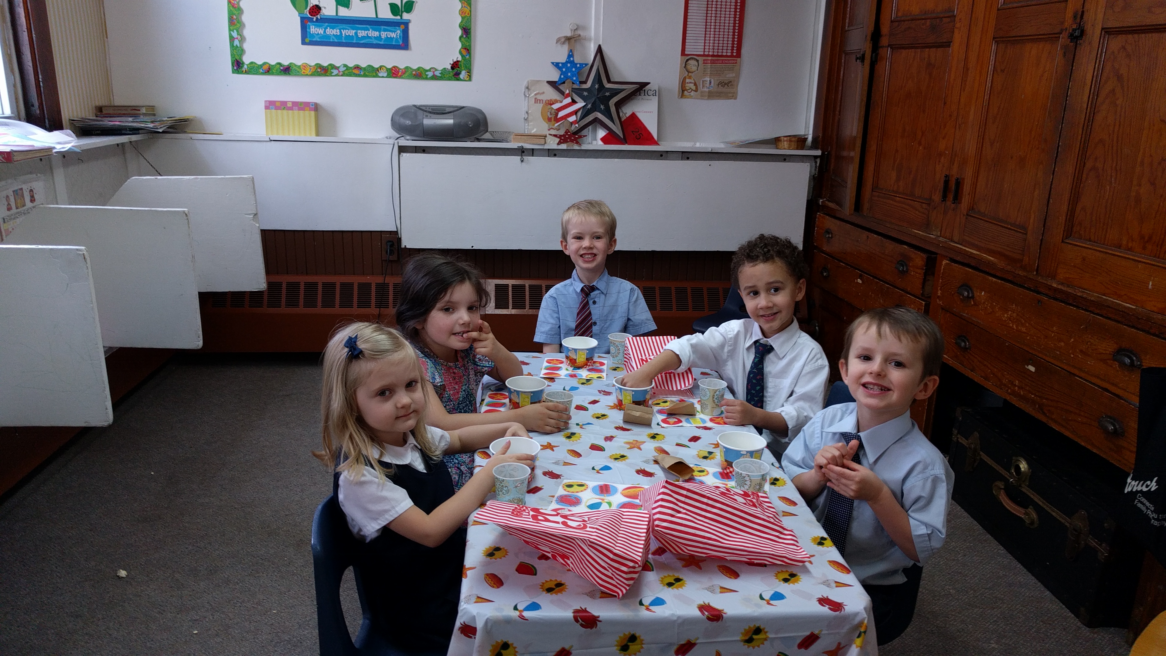 NECA ABC preschool and kindergarten students seated together at a classroom table for a class party.