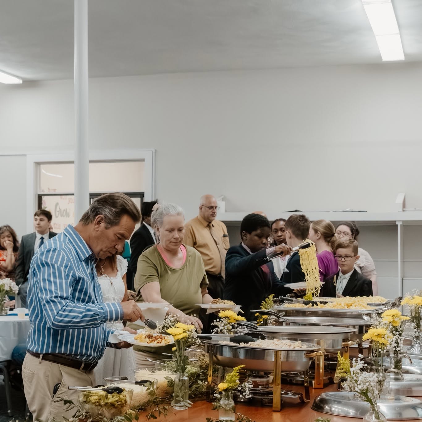 NECA families and students serving themselves at the reception following a school program.