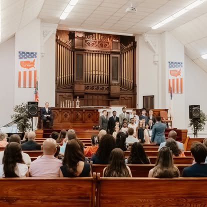 Families seated in the sanctuary for a NECA graduation ceremony.
